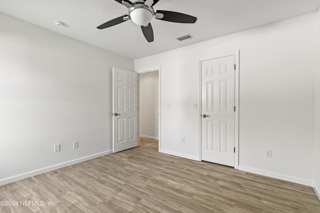 unfurnished room featuring ceiling fan, hardwood / wood-style flooring, and a textured ceiling