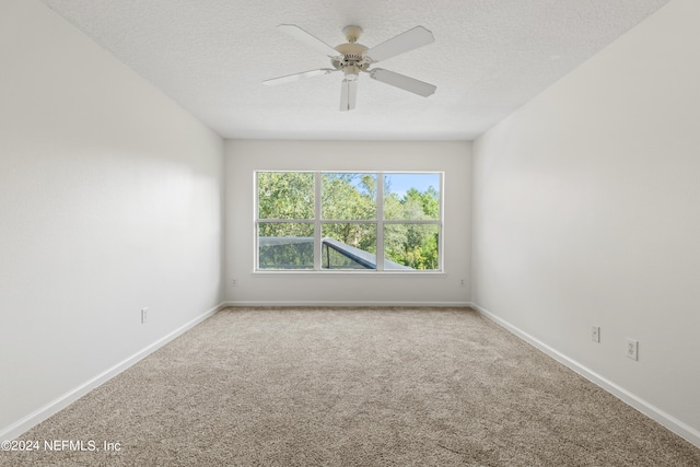 empty room with a textured ceiling, carpet flooring, and ceiling fan