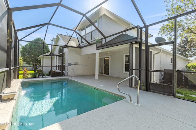 view of pool with a patio, ceiling fan, pool water feature, and glass enclosure