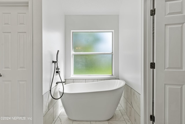 bathroom with tile walls and a bath