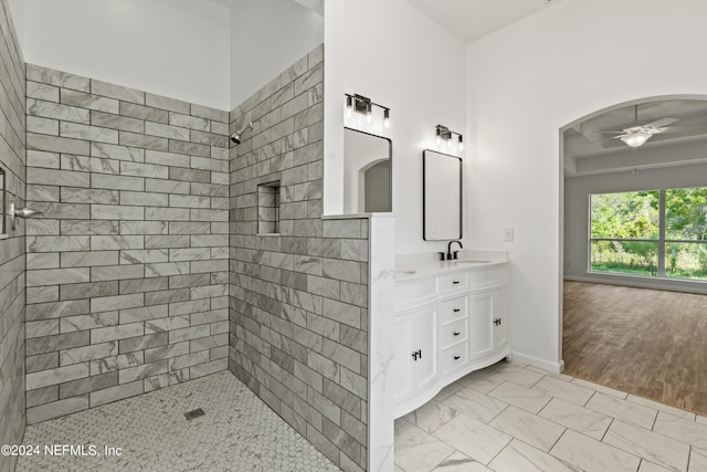 bathroom with vanity, hardwood / wood-style flooring, ceiling fan, and tiled shower