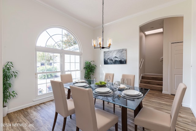 dining room featuring crown molding, a textured ceiling, wood-type flooring, and a chandelier