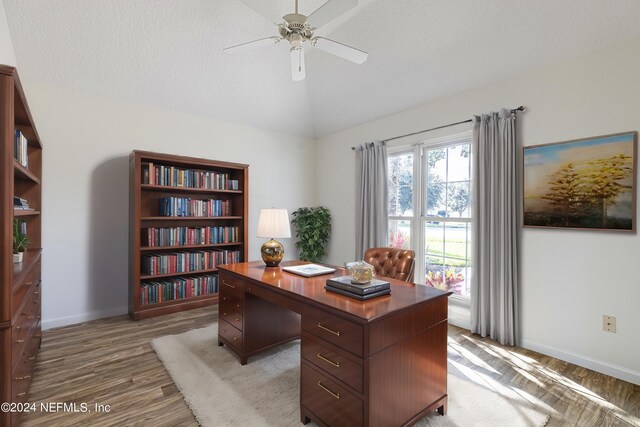 office area with a textured ceiling, vaulted ceiling, wood-type flooring, and ceiling fan