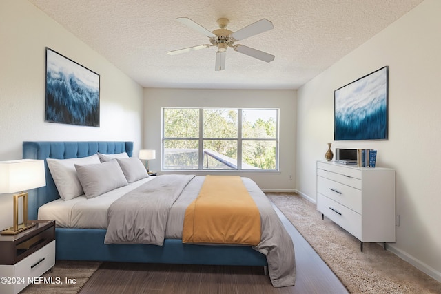 bedroom with a textured ceiling, carpet floors, and ceiling fan