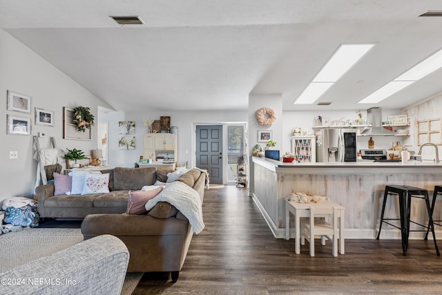 living room with dark hardwood / wood-style floors, vaulted ceiling, and sink