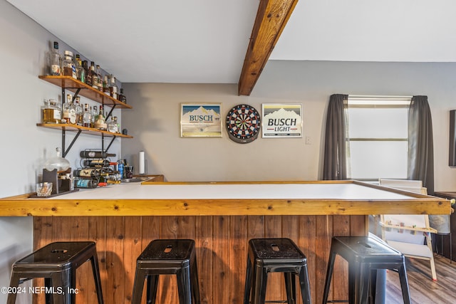 bar with hardwood / wood-style flooring and beam ceiling