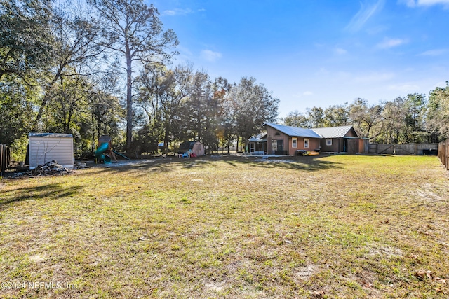 view of yard with a playground and a storage shed