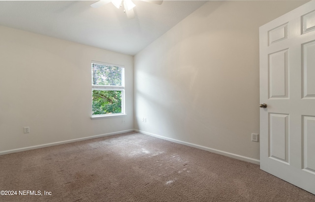 spare room featuring carpet flooring, vaulted ceiling, and ceiling fan