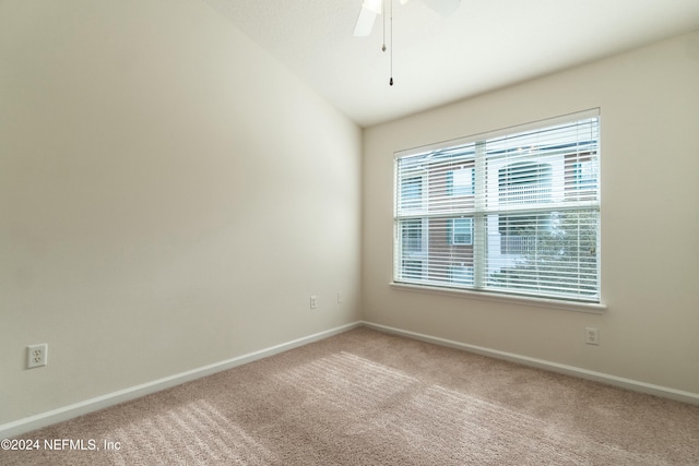 carpeted empty room with ceiling fan and lofted ceiling