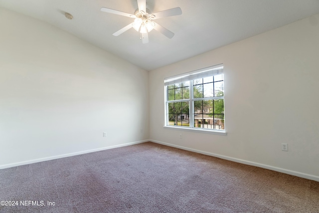 carpeted spare room featuring ceiling fan and lofted ceiling