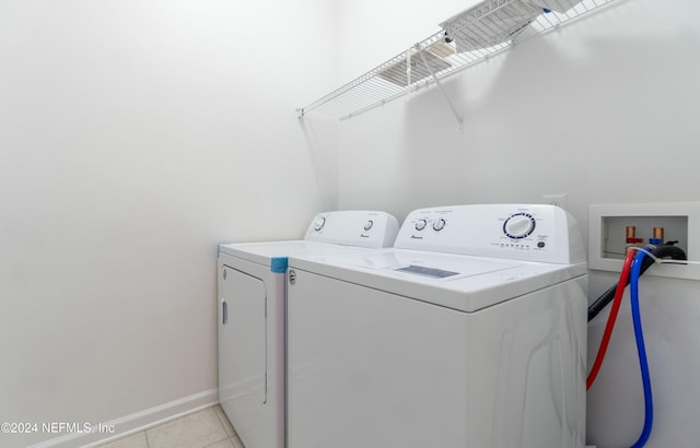 washroom with washing machine and dryer and light tile patterned flooring