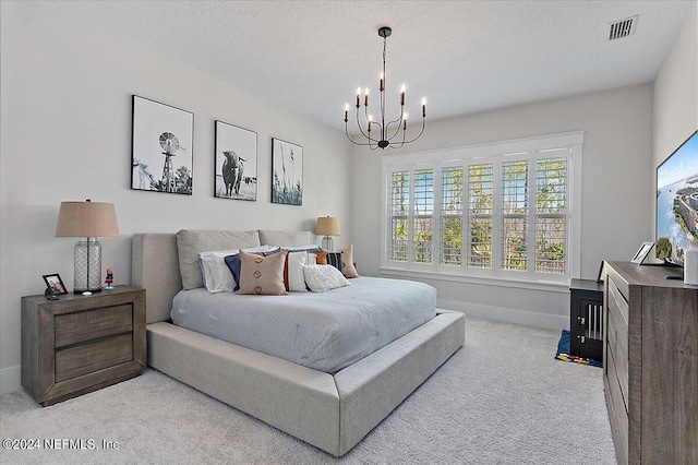 carpeted bedroom featuring an inviting chandelier and a textured ceiling