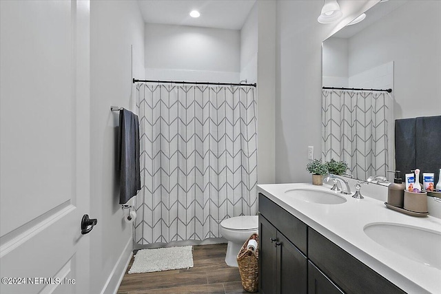 bathroom with toilet, hardwood / wood-style floors, and dual vanity