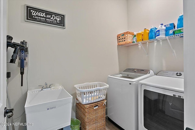 clothes washing area with separate washer and dryer and sink