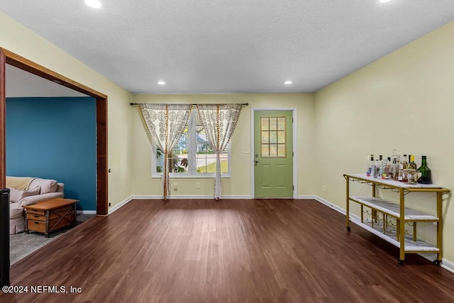 interior space with a textured ceiling and dark hardwood / wood-style flooring