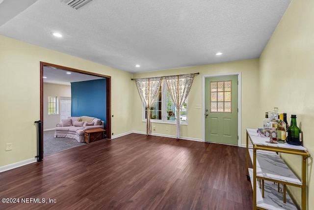 foyer featuring a textured ceiling and dark wood-type flooring