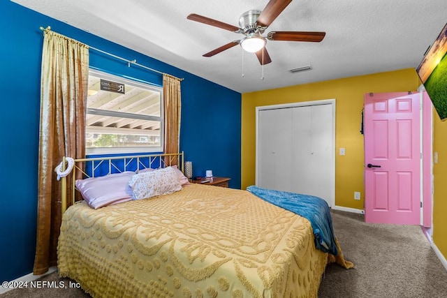 carpeted bedroom featuring a closet, a textured ceiling, and ceiling fan