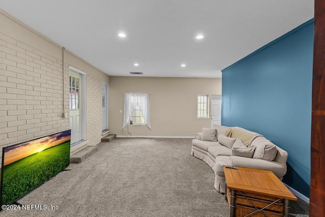 living room with carpet flooring and brick wall