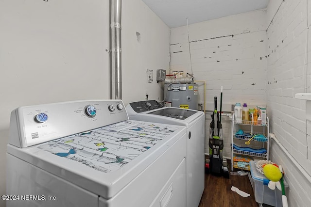 washroom featuring dark wood-type flooring, water heater, and washing machine and dryer