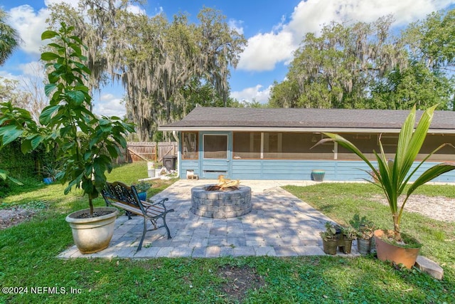 view of front of house with a patio, a front yard, and a fire pit