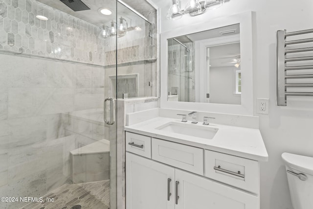 bathroom featuring ceiling fan with notable chandelier, toilet, a shower with door, and radiator heating unit