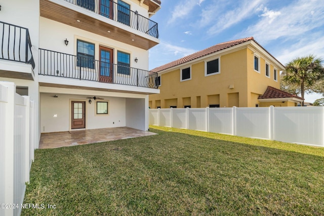 back of property with a balcony, a yard, and a patio