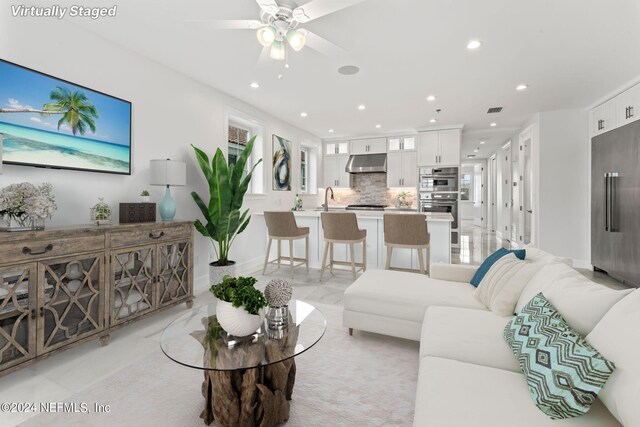 living room featuring ceiling fan and sink