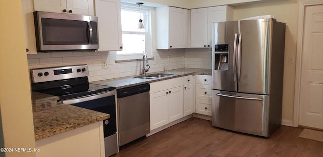 kitchen featuring white cabinetry, backsplash, stainless steel appliances, dark hardwood / wood-style flooring, and pendant lighting