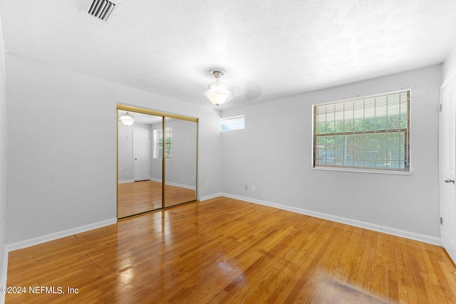 unfurnished bedroom featuring wood-type flooring and a closet