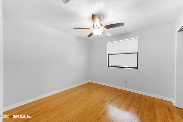 spare room featuring ceiling fan, hardwood / wood-style floors, and a textured ceiling