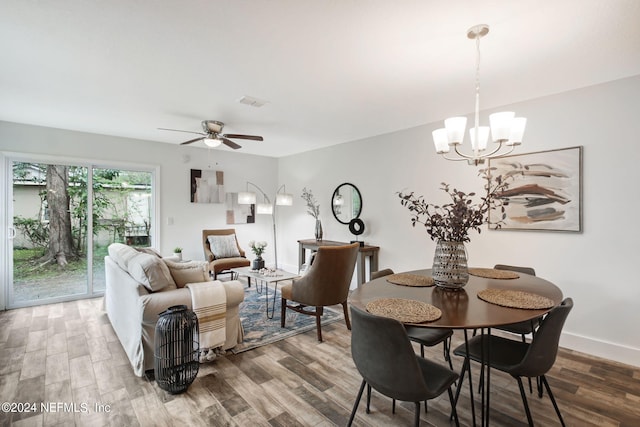 dining space with hardwood / wood-style floors and ceiling fan with notable chandelier