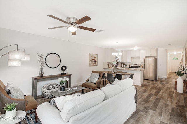 living room with dark hardwood / wood-style floors and ceiling fan with notable chandelier