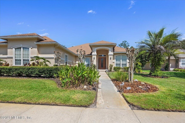 mediterranean / spanish-style home with a front lawn