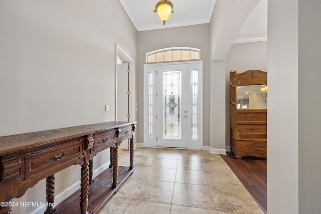 tiled foyer featuring crown molding