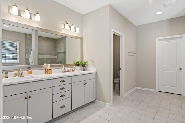 full bath with double vanity, toilet, walk in shower, and a sink