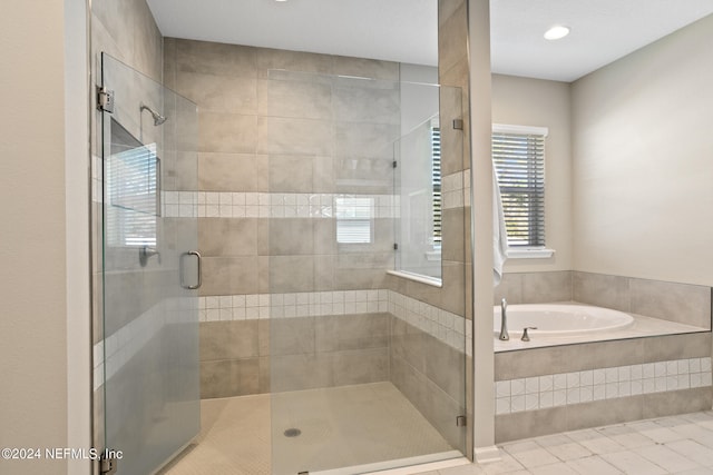 bathroom with tile patterned flooring, a stall shower, and a garden tub