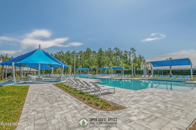 pool with a patio area and fence