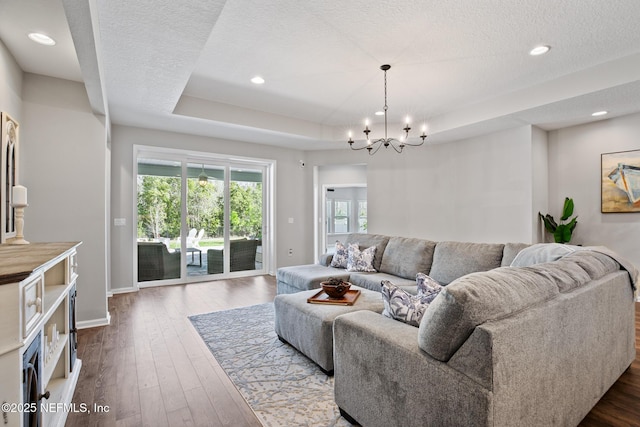 living room with baseboards, a tray ceiling, recessed lighting, dark wood-style flooring, and a textured ceiling