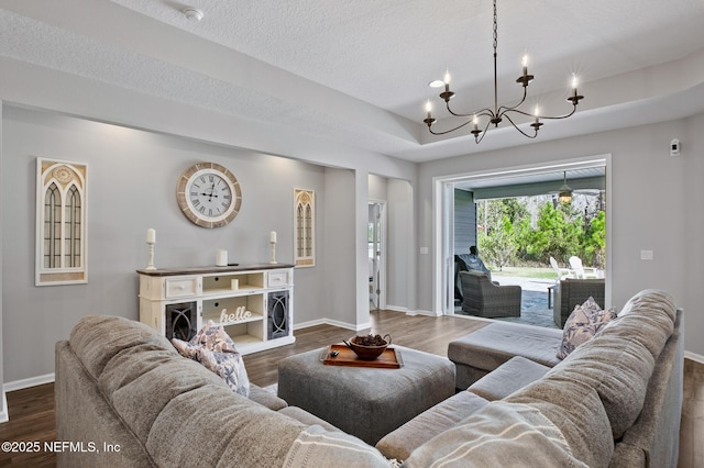 living area with baseboards, a raised ceiling, and dark wood-style floors