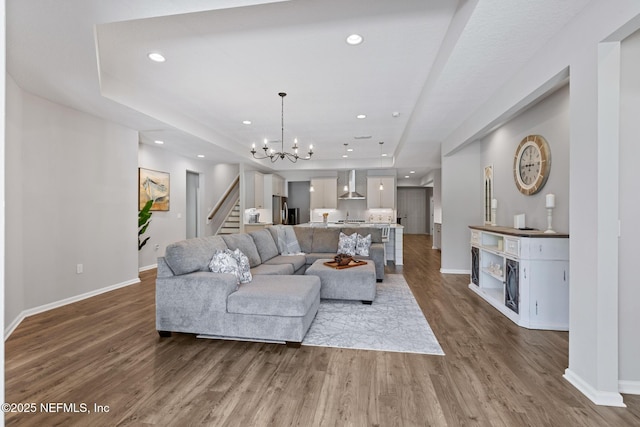 living room with wood finished floors, recessed lighting, a fireplace, a chandelier, and stairs