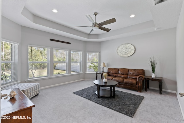 carpeted living room featuring a raised ceiling, recessed lighting, a ceiling fan, and baseboards