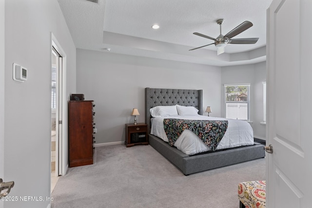 bedroom featuring baseboards, ceiling fan, a textured ceiling, a raised ceiling, and carpet flooring