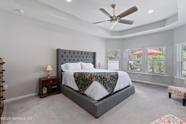 bedroom with a ceiling fan, baseboards, carpet floors, a tray ceiling, and recessed lighting