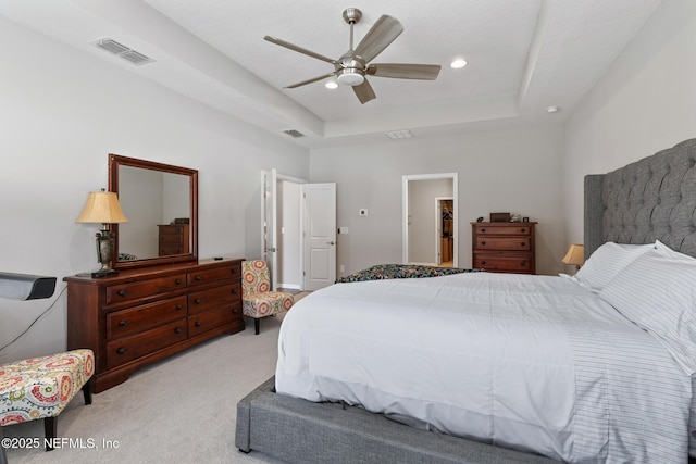 bedroom with visible vents, light colored carpet, a tray ceiling, recessed lighting, and a ceiling fan