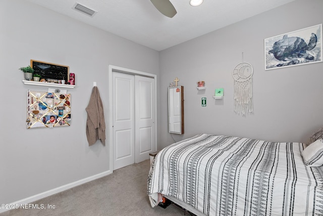 carpeted bedroom featuring a closet, baseboards, visible vents, and a ceiling fan