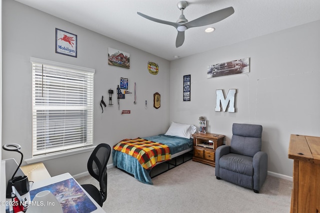 bedroom with a ceiling fan, baseboards, and light carpet