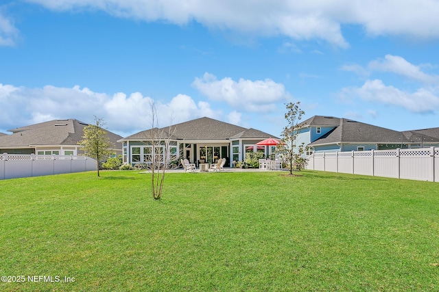 back of house with a lawn, a fenced backyard, and a patio area