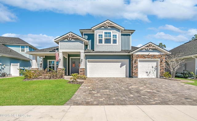 craftsman-style home featuring decorative driveway, a garage, and a front lawn