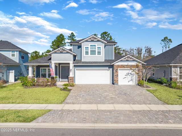 craftsman inspired home featuring an attached garage, decorative driveway, and a front lawn