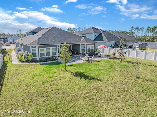 back of house featuring a yard, a patio, and a fenced backyard